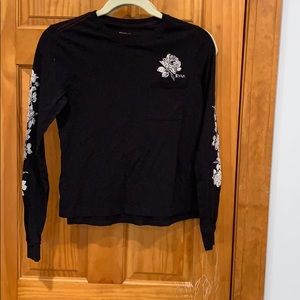 Black Top with flowers on the sleeves and pocket.